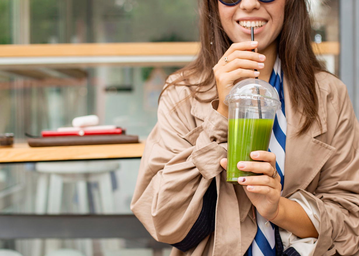 happy woman drinking green smoothie